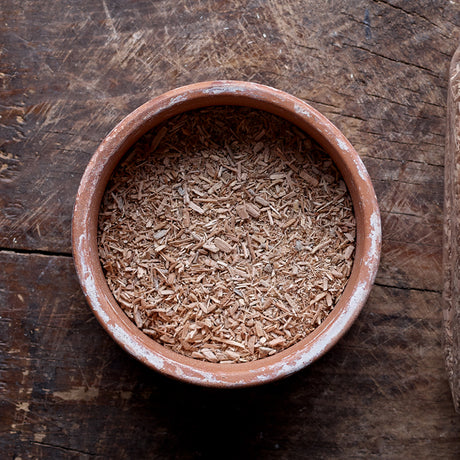 Top view of a mixture of fine and medium-sized particles of Alder smoking wood dust in a flat round bowl.