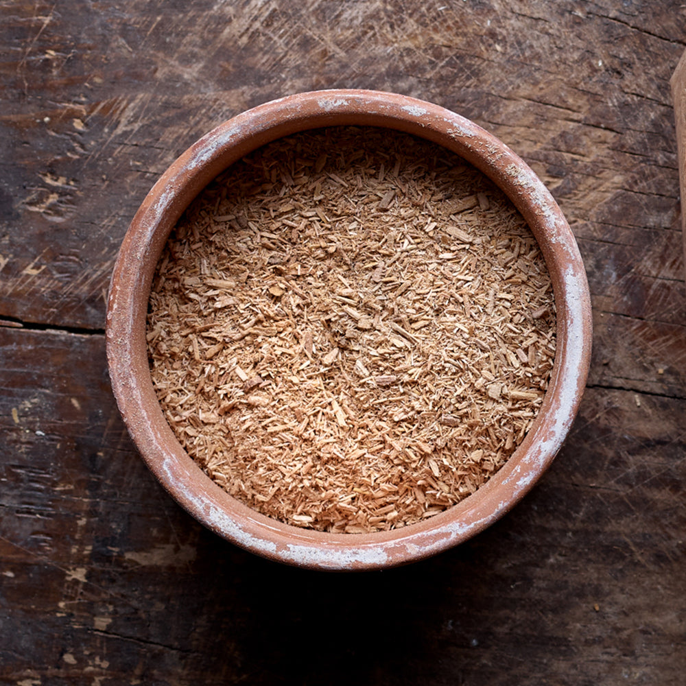 Top view of a mixture of fine and large particles of Cherry smoking wood dust in a flat round bowl.