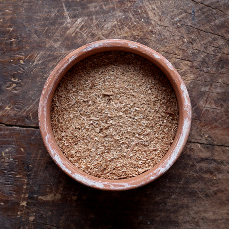 Top view of a mixture of small and large particles of Hickory smoking wood dust in a flat round bowl.