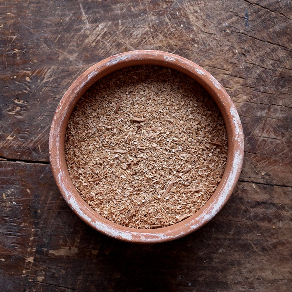 Top view of a mixture of small and large particles of Hickory smoking wood dust in a flat round bowl.