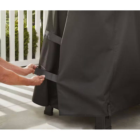 Searwood XL 600 Premium Grill Cover person attaching cover to grill