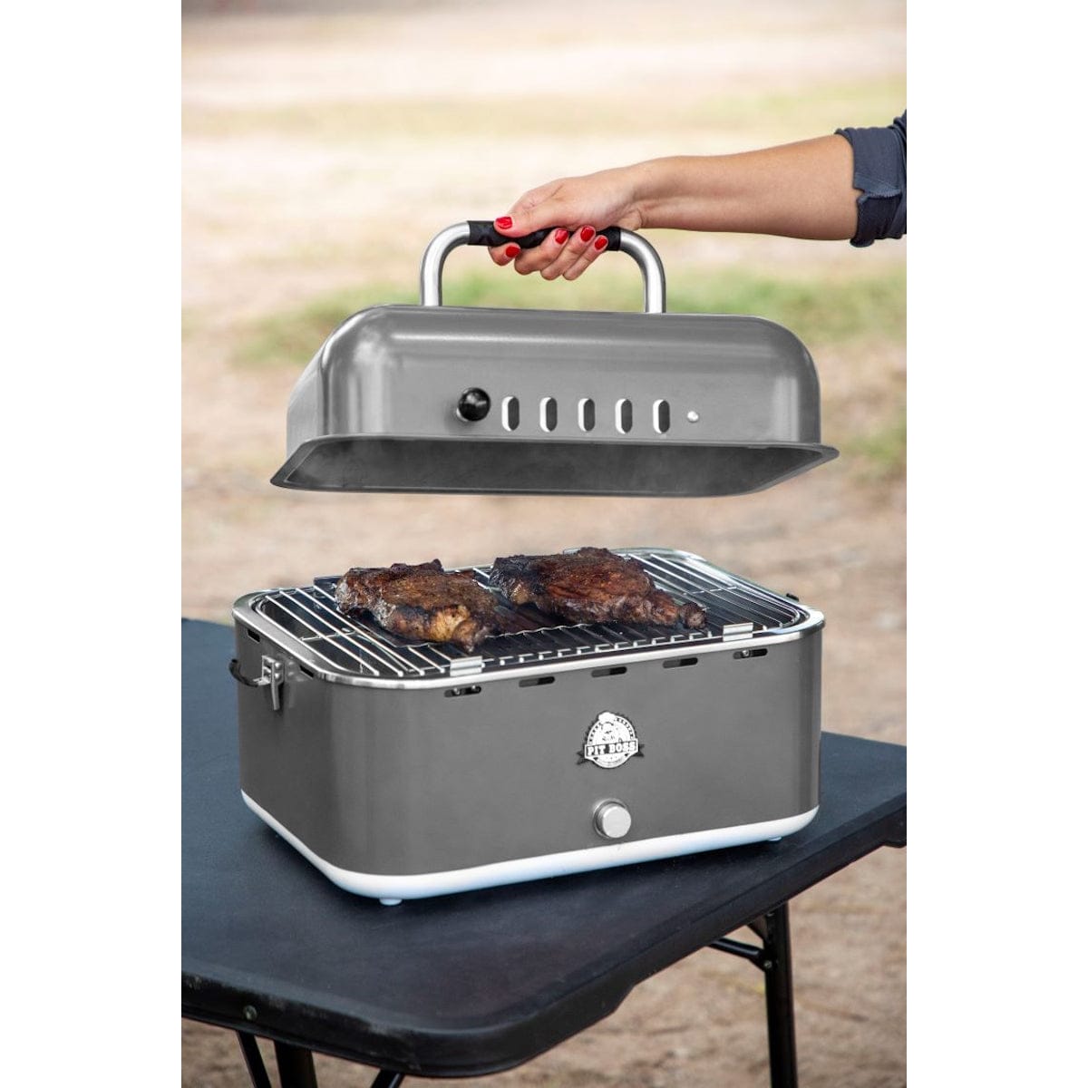 Pit Boss Grills Portable Charcoal Grill man removing top cover