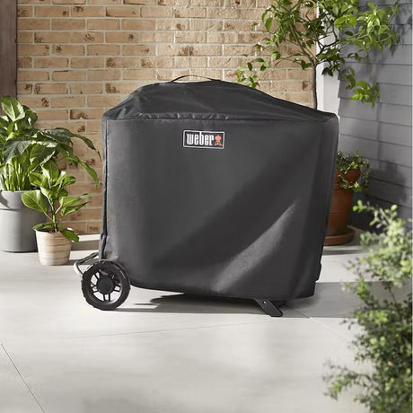 Premium barbecue cover for Weber Traveler covered grill in room with plants