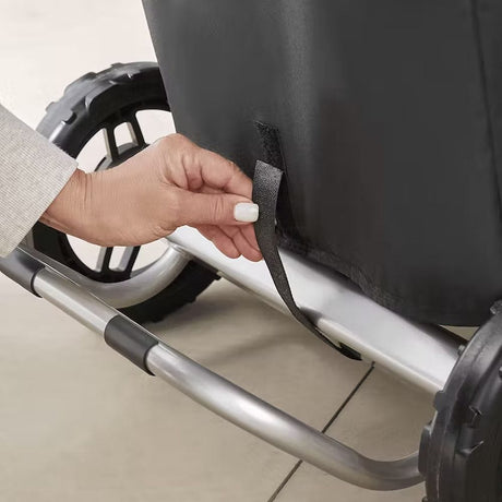 Premium barbecue cover for Weber Traveler man securing the cover on grill