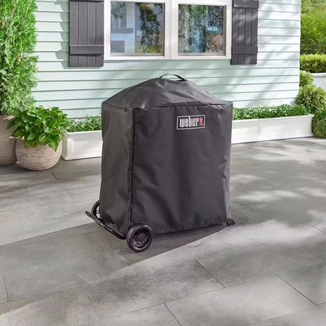 Premium barbecue cover for Weber Traveler covered grill in front of house