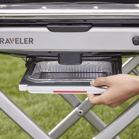 Grill grease tray being pulled out on a Weber Traveler Gas Barbecue