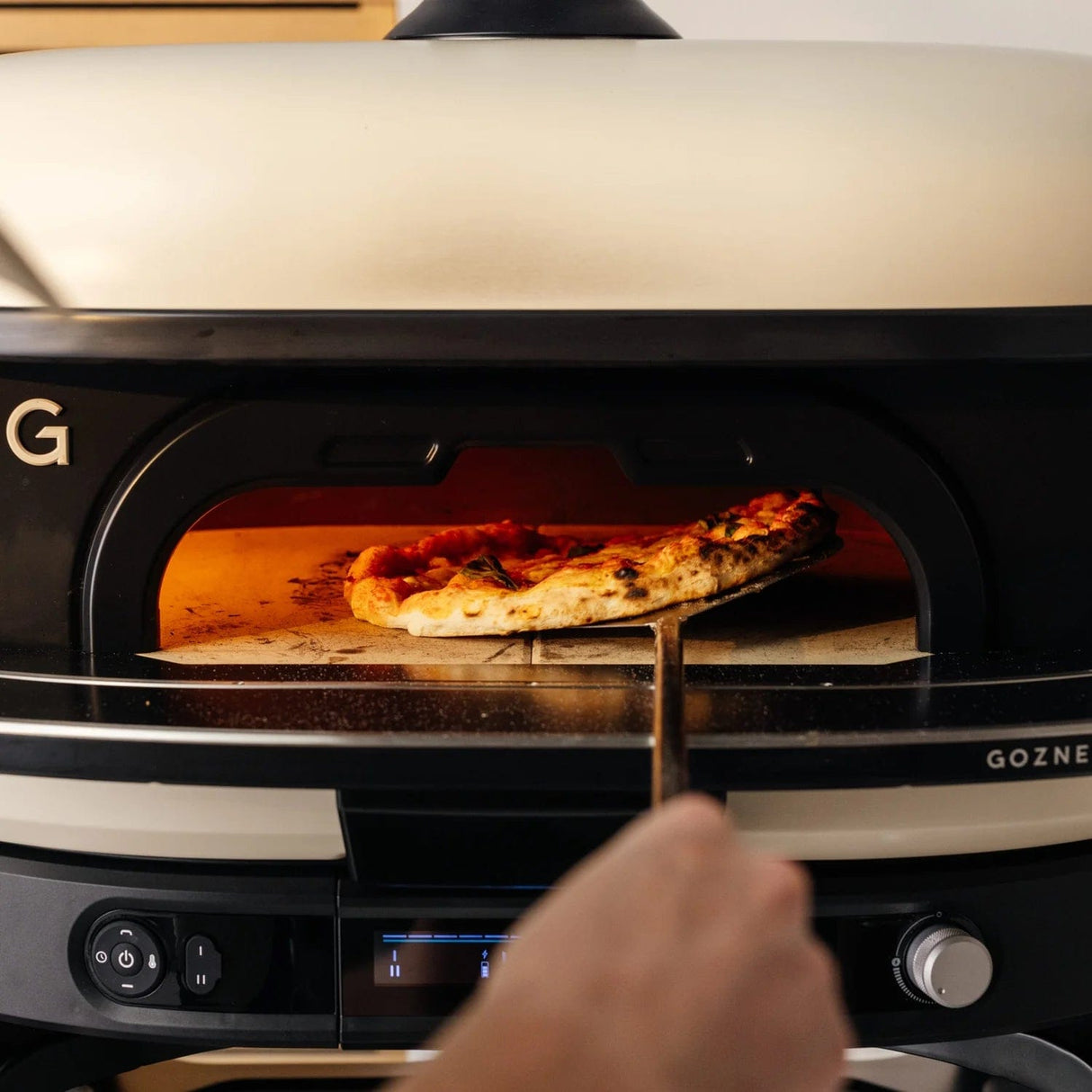 Dome XL Gen 2 Neapolitan Arch man lifting pizza in oven