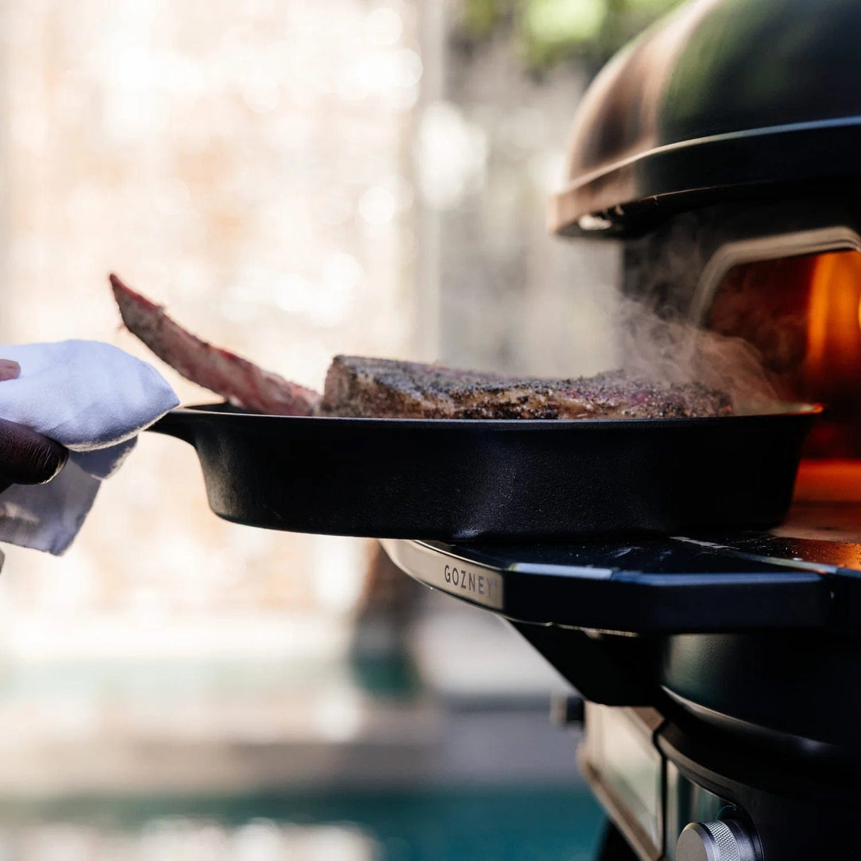 Dome Gen 2 Mantel man holding cast iron pan with steak