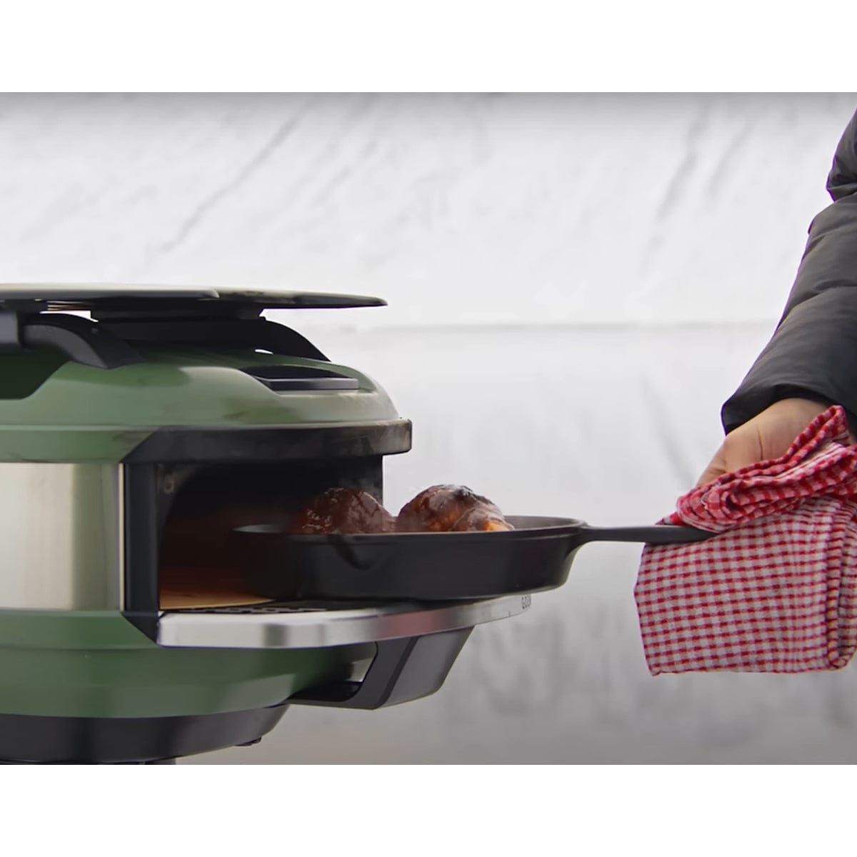 man holding pan with food on Tread Mantel