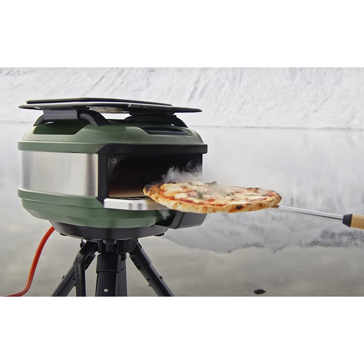holding pizza with Venture Turning Peel in front of pizza oven