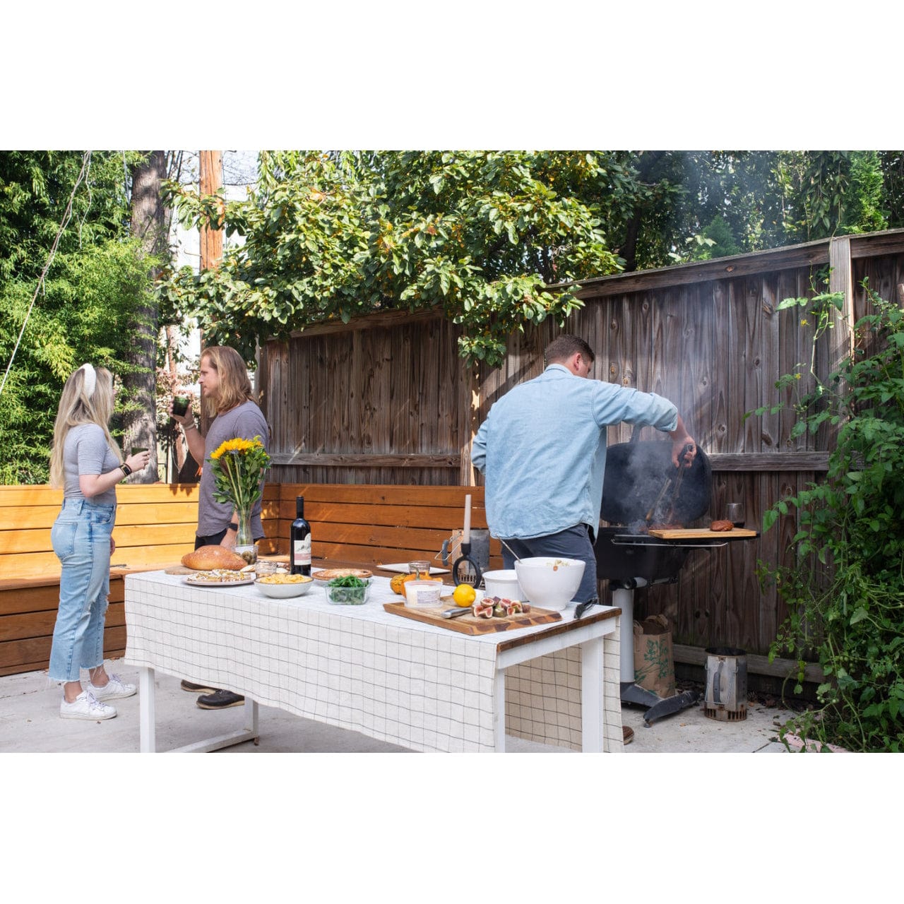 people preparing food on PK360 Aluminium Charcoal Grill & Smoker and chating in backyard