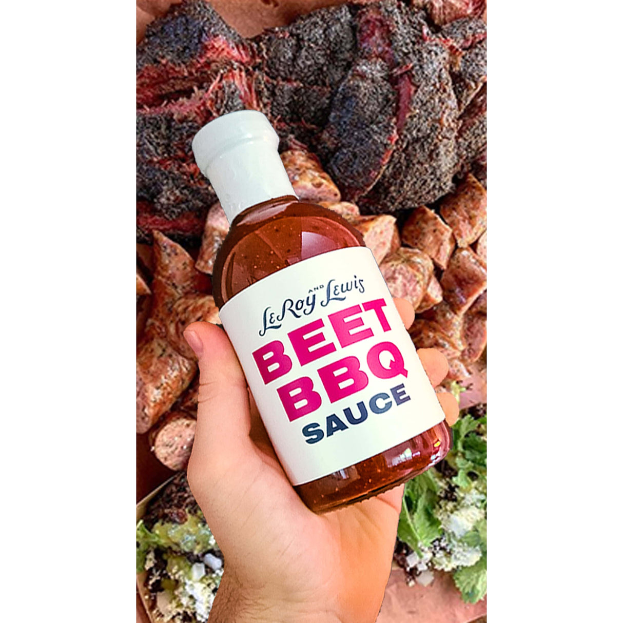LeRoy & Lewis Beet BBQ Sauce hand holding sauce bottle over meat