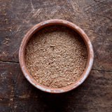 Top view of a mixture of small and large particles of Hickory smoking wood dust in a flat round bowl.