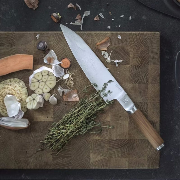 Fiskars Norden Large Cook's Knife on a cutting board with vegetables