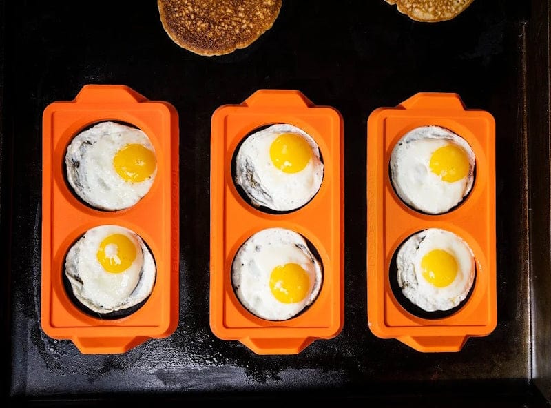 3 pieces of Blackstone - 2 Section Egg Ring Tray shown with cooked eggs on all sections