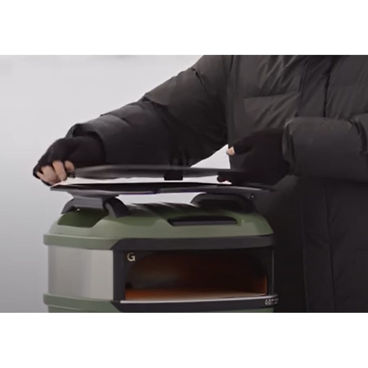 man holding Tread Pizza Oven Roof Rack Server above pizza oven