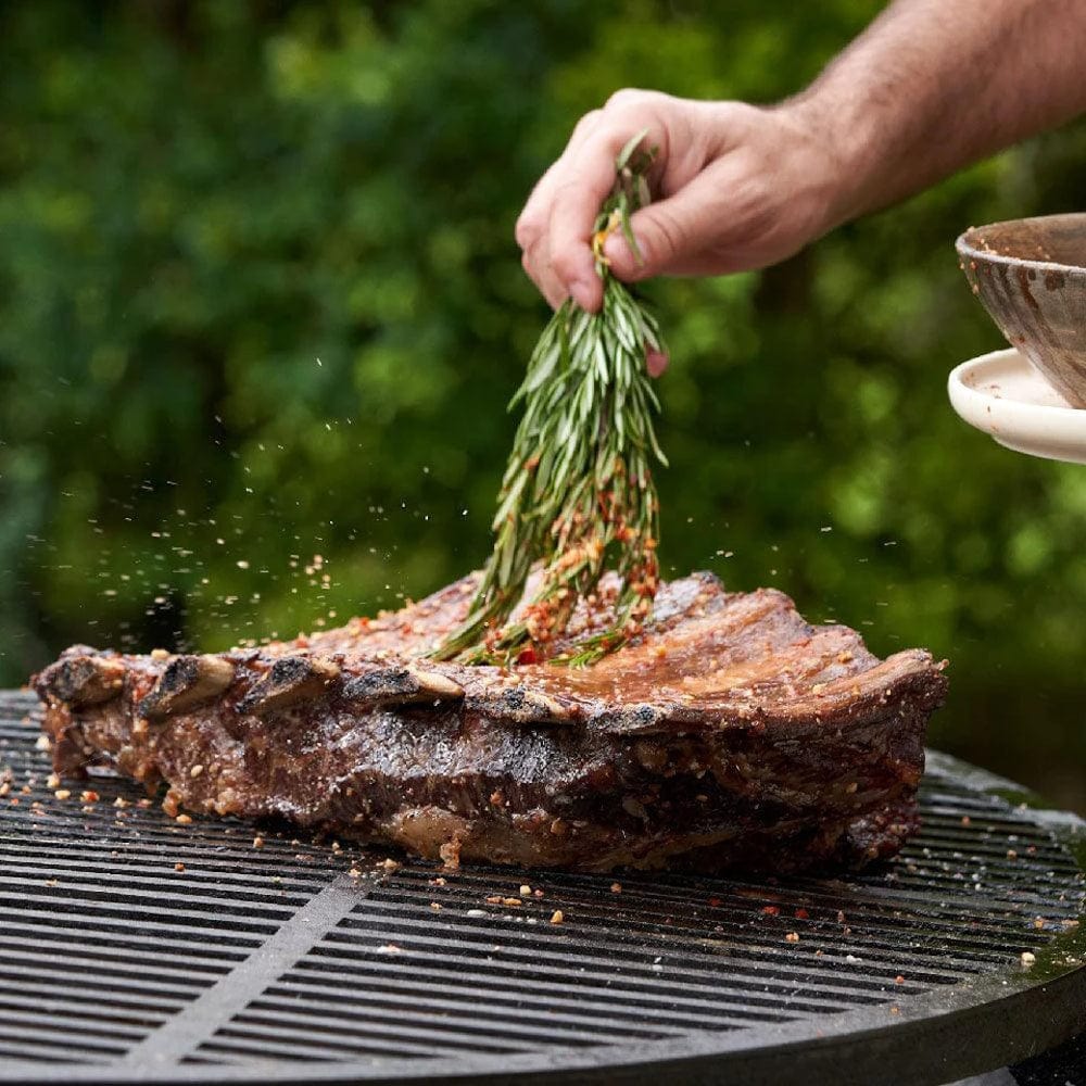 seasoning meat with Al Frugoni Asado All Purpose Rub and rosemary