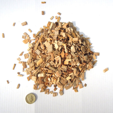 Close-up image of an ample amount of Cherry Wood Smoking Chips and a coin penny as its chip size comparison reference
