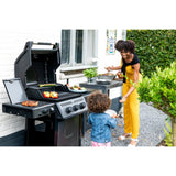 a woman and child grilling food on Napoleon Freestyle 365 SIB and smiling