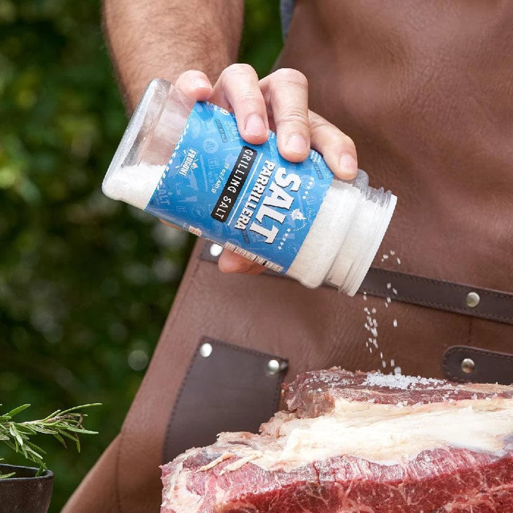 person seasoning a steak with Al Frugoni Grilling Salt