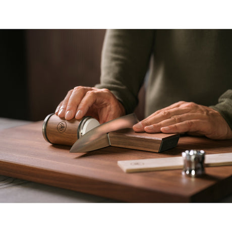 a man using HORL 3 Walnut on a knife