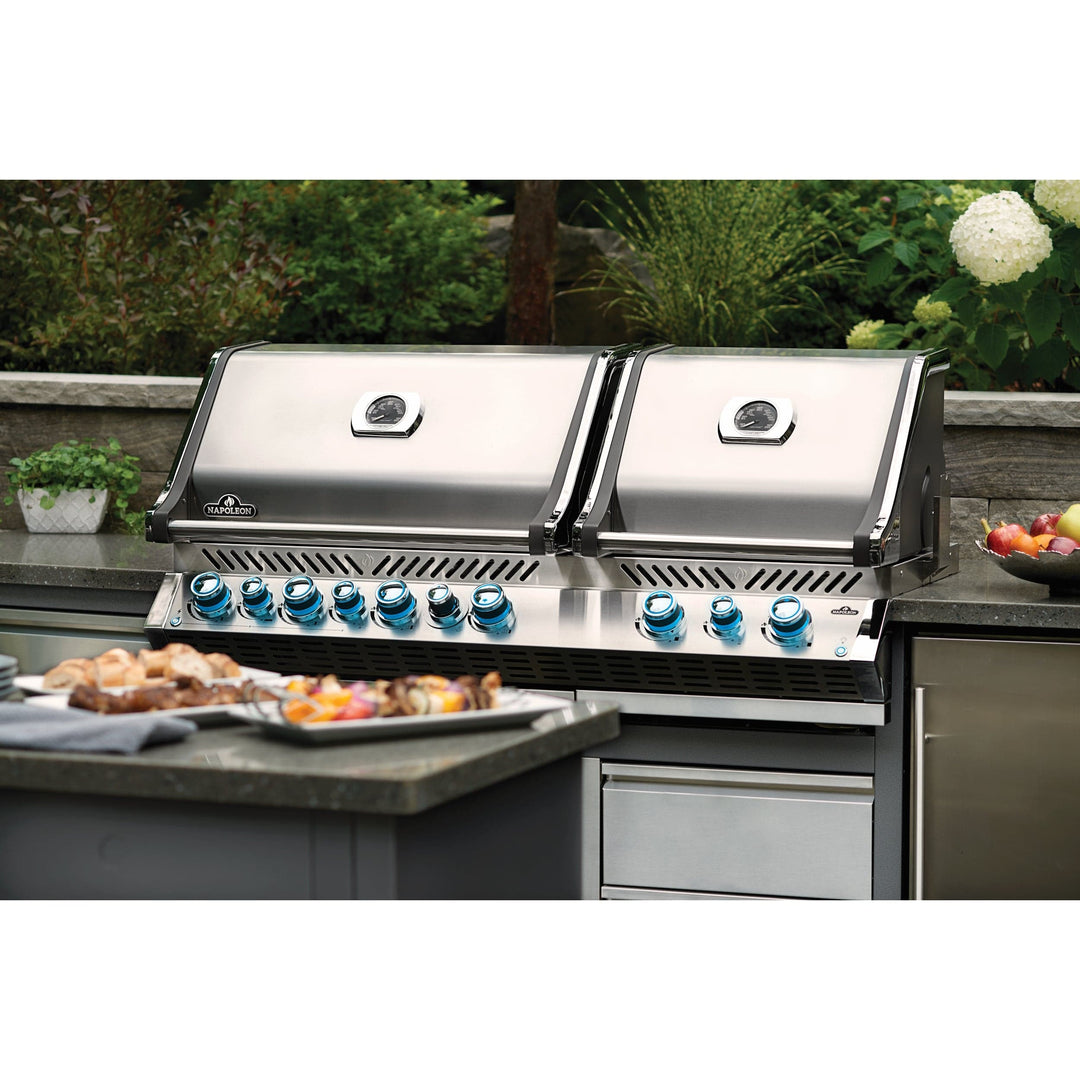 Napoleon Prestige PRO 825 RSBI in use outdoors with lids closed surrounded by grilled food