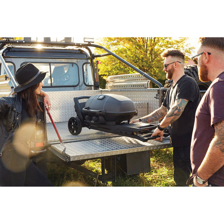 people folding Napoleon Phantom TravelQ portable into a truck