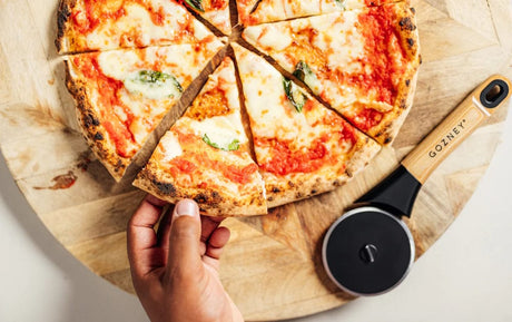 taking slice of pizza sliced with Gozney Pizza Cutter