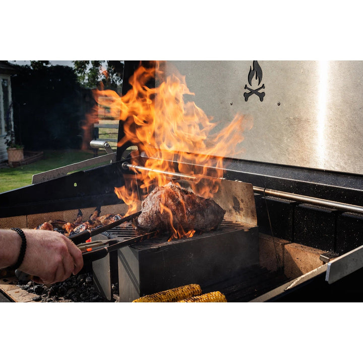 fire flame and grilling meat on a Large Asado Grill on Trolley