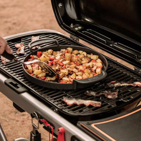 grilling food on a pan on a Weber Traveler Gas Barbecue