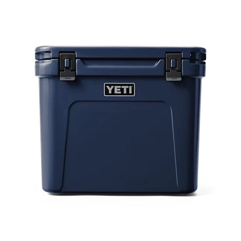  front side of a closed Navy YETI Roadie - 60 Wheeled Cool Box  shown with retracted handle