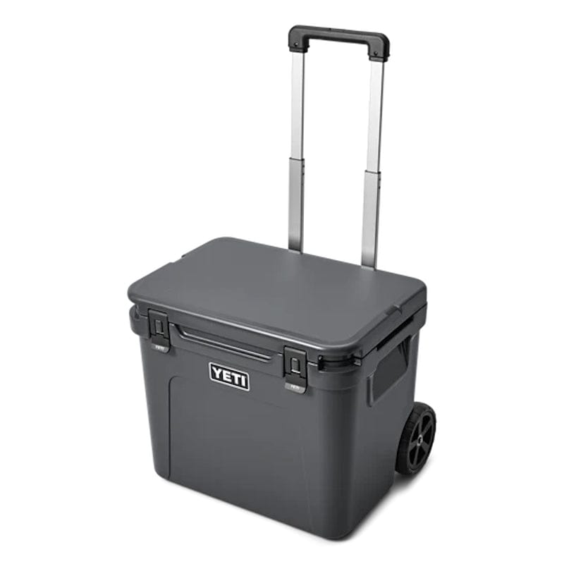 a closed lid Charcoal  YETI Roadie - 60 Wheeled Cool Box shown with periscopic handle