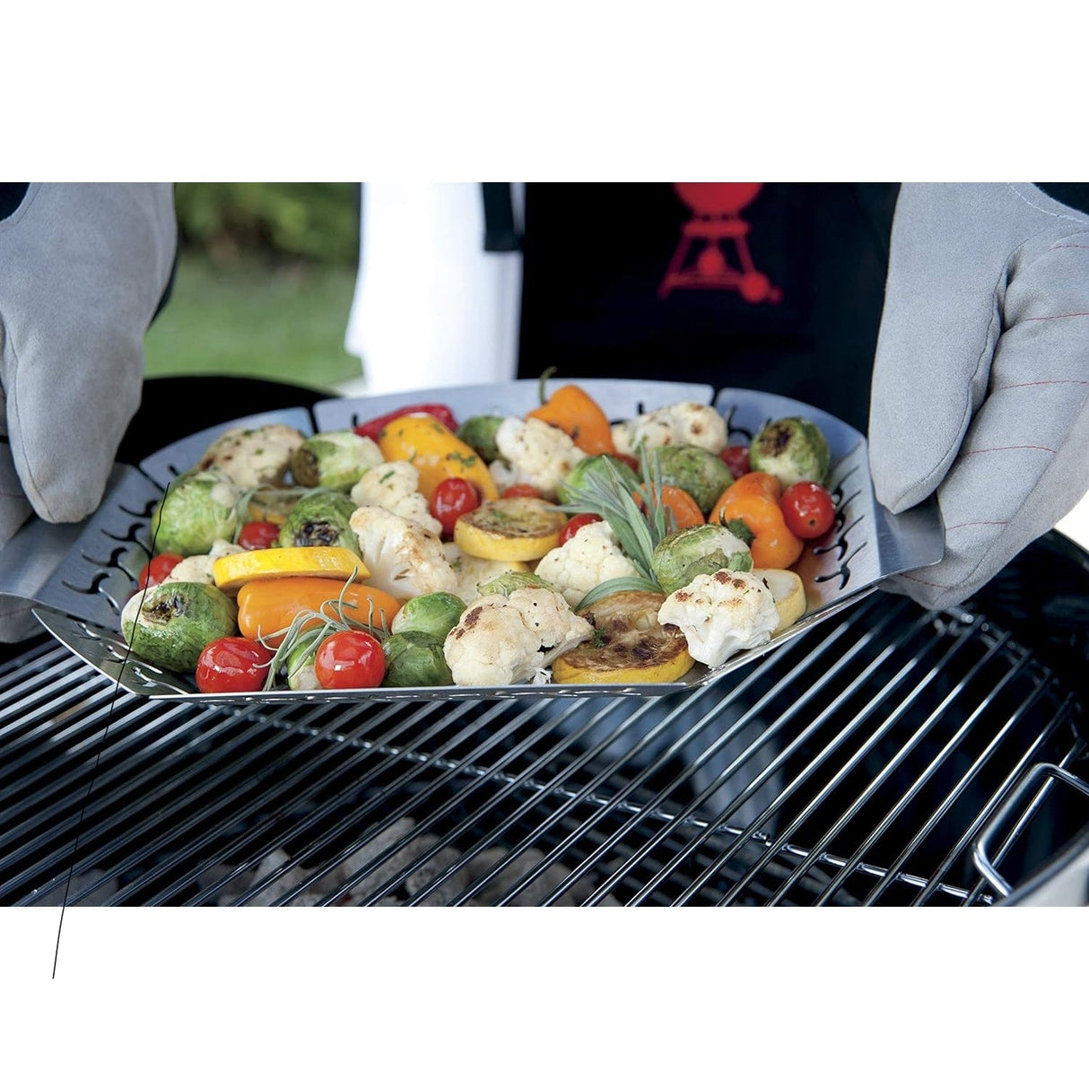 a person holding Weber Premium Large Grilling Basket with grilled vegetables