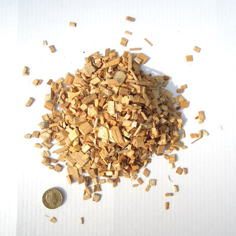 Close-up image of an ample amount of Maple Wood Smoking Chips and a coin penny as a chip size comparison reference.