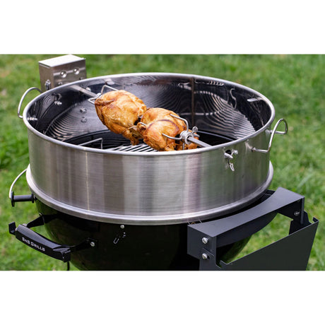 Close-up view of a working Slow 'N Sear® Kettle Ring Rotisserie Kit placed on top of a kettle grill with 2 skewered whole chickens.
