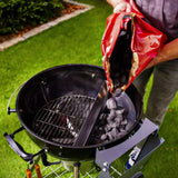 pouring charcoal into Slow 'N Sear - Kettle Grill 