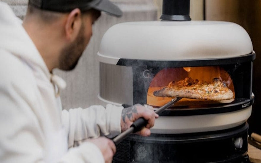 preparing pizza in Gozney Dome S1 outdoor oven