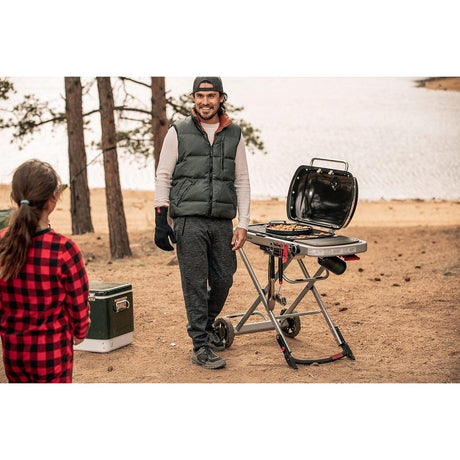 people smiling and preparing food on a Weber Traveler Gas Barbecue