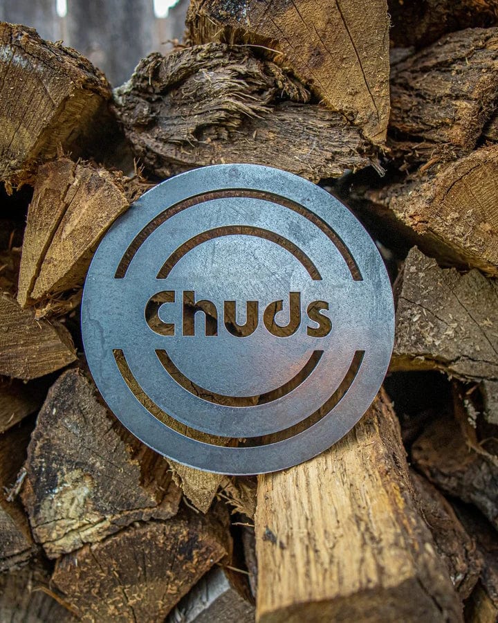 The Chuds Magic trivet displayed on top of chopped woods