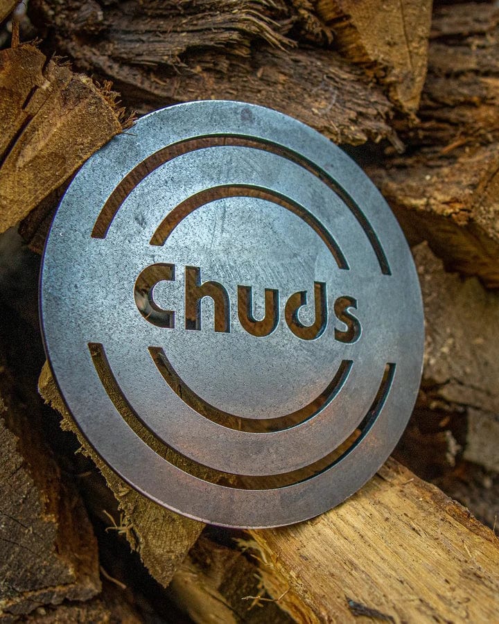 The Chuds Magic trivet displayed on top of chopped woods